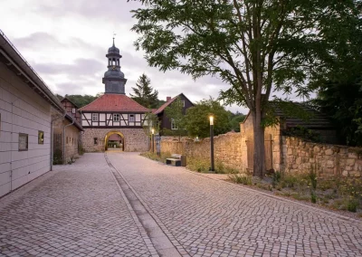 Eingangsbereich des Wirtschaftshofes Kloster Michaelstein mit naturnaher Wegeführung und historischem Gebäudebestand.